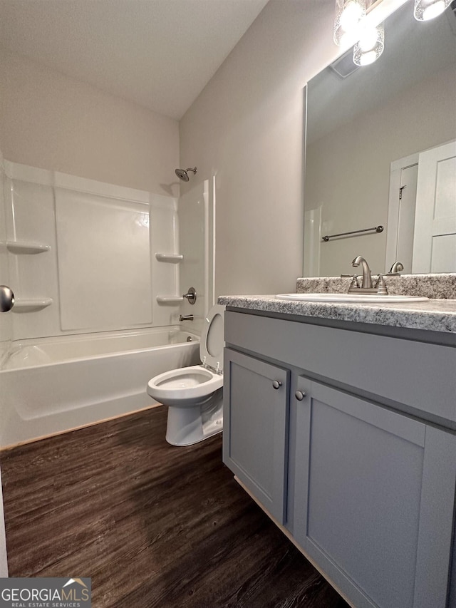 full bathroom with vanity, wood-type flooring, bathtub / shower combination, and toilet