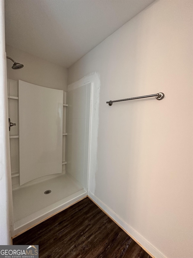 bathroom with wood-type flooring and a shower