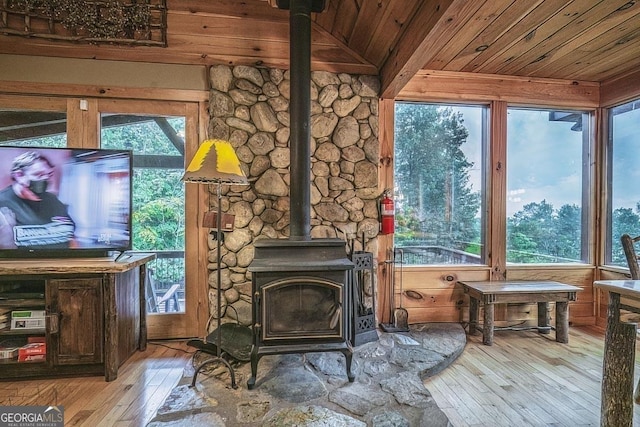 details with a wood stove, wood ceiling, a fire extinguisher, and wood finished floors