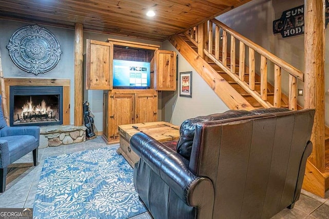 tiled living room featuring a stone fireplace and wood ceiling