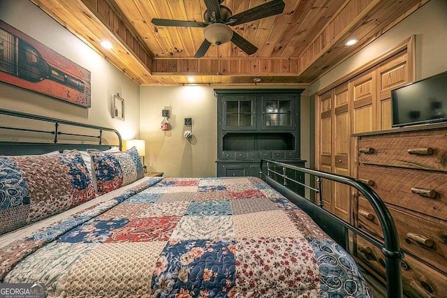 bedroom featuring wooden ceiling, a raised ceiling, and ceiling fan