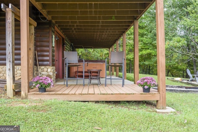 deck featuring a lawn and a hot tub