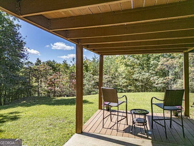 view of patio with a deck and view of wooded area