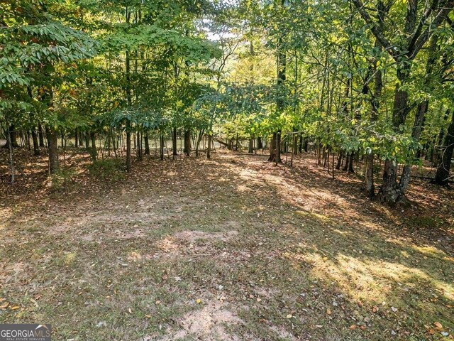 back of property featuring a deck, a yard, and an outdoor fire pit