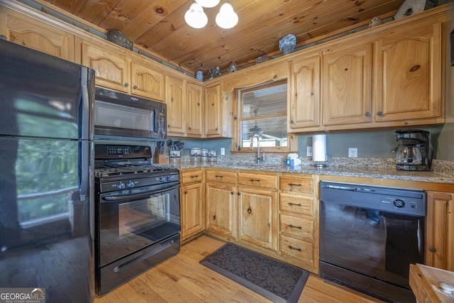 kitchen featuring wood ceiling, a sink, light stone countertops, light wood-type flooring, and black appliances