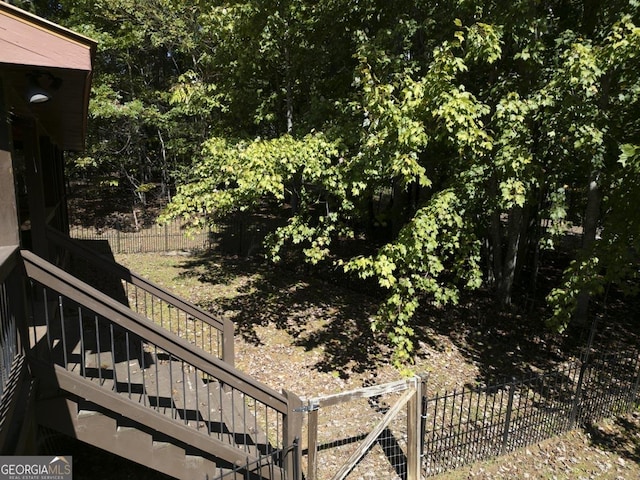 view of yard with fence and stairway
