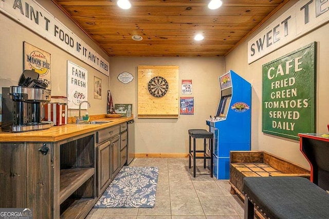 bar area with a sink, recessed lighting, wooden ceiling, light tile patterned floors, and baseboards