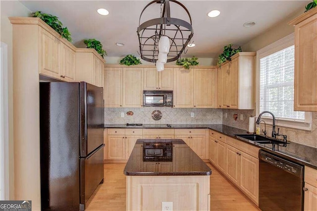 kitchen featuring black appliances, a kitchen island, sink, and light brown cabinets