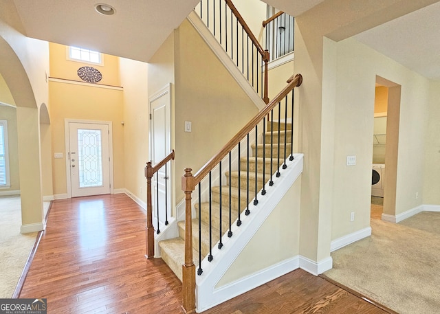 foyer entrance with hardwood / wood-style floors and washer / dryer