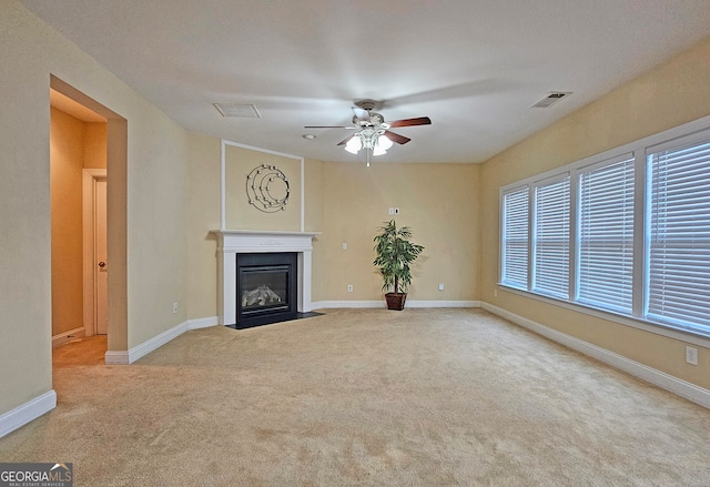 unfurnished living room featuring ceiling fan and light colored carpet