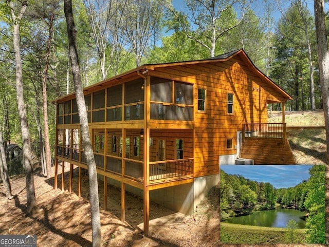 exterior space featuring a sunroom and a deck with water view