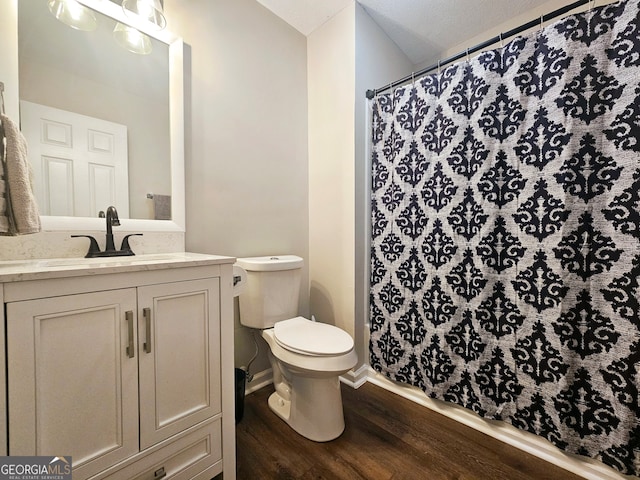 bathroom with vanity, hardwood / wood-style floors, toilet, and curtained shower