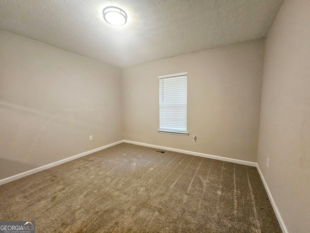 carpeted spare room featuring a textured ceiling