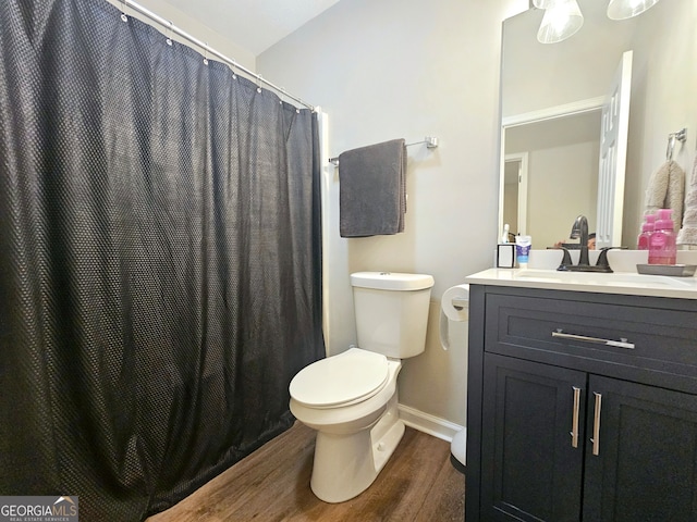 bathroom featuring a shower with curtain, hardwood / wood-style flooring, vanity, and toilet