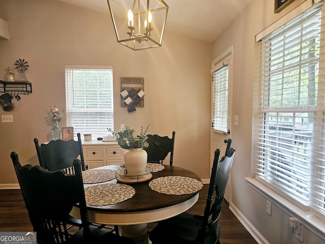 dining room featuring lofted ceiling, dark hardwood / wood-style floors, and a notable chandelier