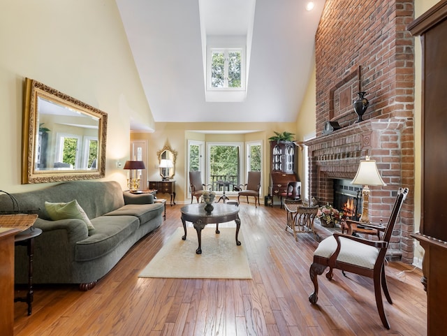 living room with a fireplace, light hardwood / wood-style flooring, and high vaulted ceiling