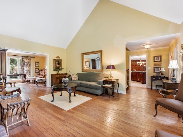 living room with a notable chandelier, light wood-type flooring, ornamental molding, and high vaulted ceiling