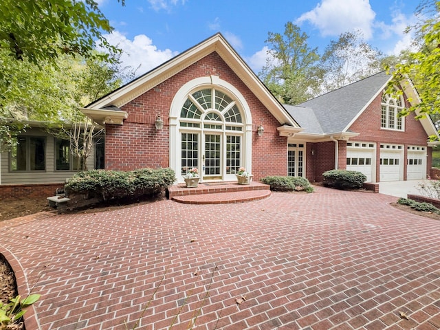 4394 Holly Springs Rd, Pendergrass, GA 30567 - view of front of house with driveway, brick siding, a garage, and french doors