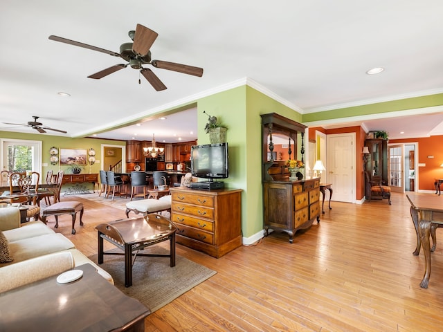 living room with ceiling fan with notable chandelier, light hardwood / wood-style flooring, and crown molding