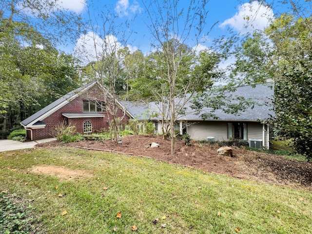 view of front of home with cooling unit and a front lawn