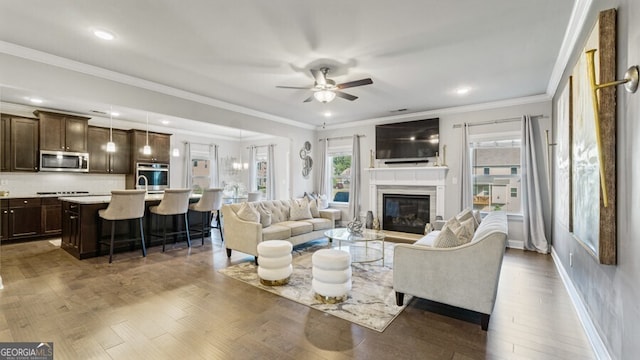 living room featuring ornamental molding, ceiling fan, and dark hardwood / wood-style floors