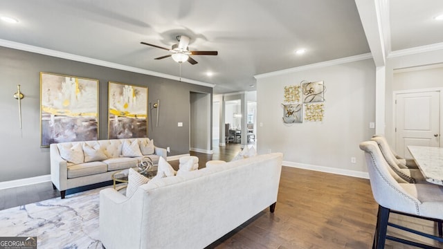 living room featuring ceiling fan, ornamental molding, and dark hardwood / wood-style flooring