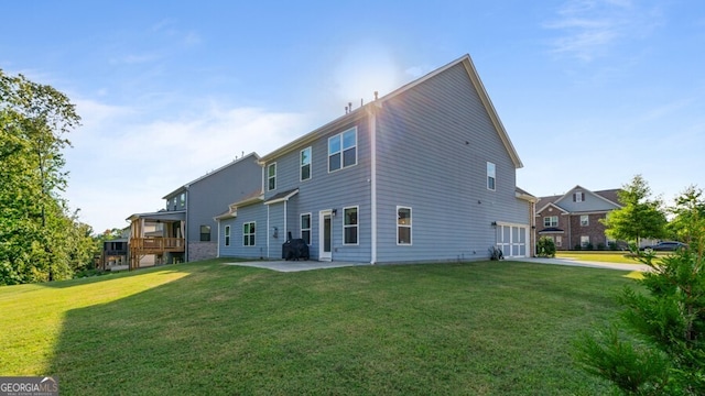 rear view of house featuring a patio, a yard, and a wooden deck