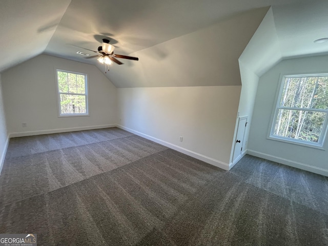 additional living space featuring ceiling fan, lofted ceiling, and dark colored carpet