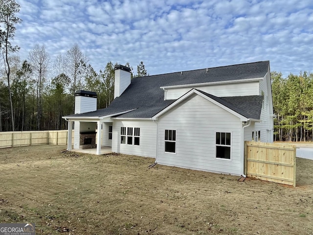 rear view of property featuring a patio and a yard