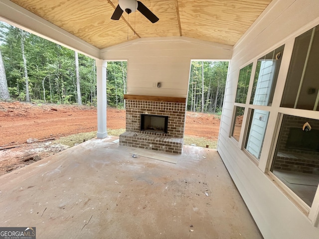 view of patio featuring an outdoor brick fireplace and ceiling fan