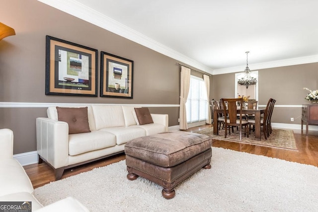 living room with hardwood / wood-style floors, ornamental molding, and a chandelier