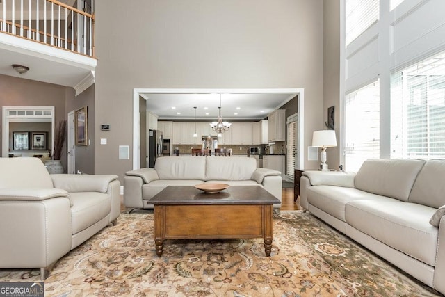 living room featuring high vaulted ceiling and an inviting chandelier