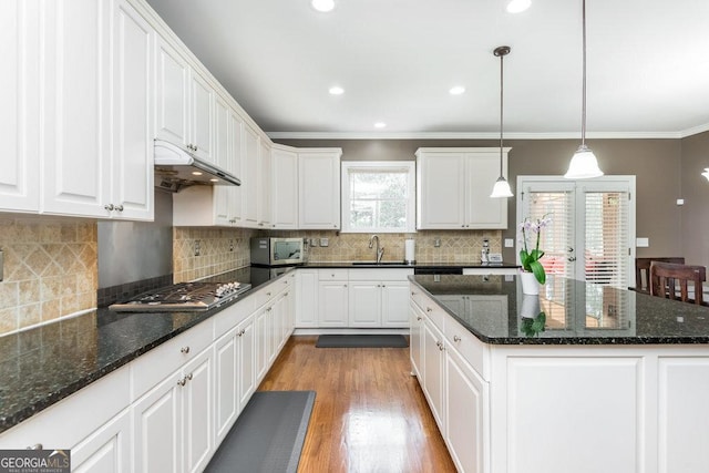 kitchen featuring white cabinetry, crown molding, pendant lighting, and appliances with stainless steel finishes