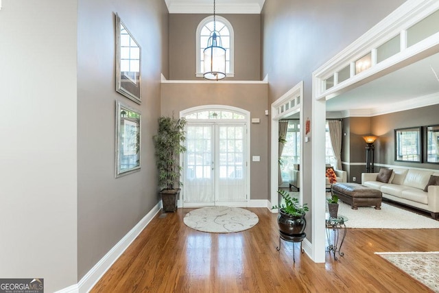 foyer entrance with hardwood / wood-style floors, french doors, and a healthy amount of sunlight