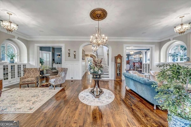 foyer featuring an inviting chandelier, crown molding, dark hardwood / wood-style flooring, and plenty of natural light