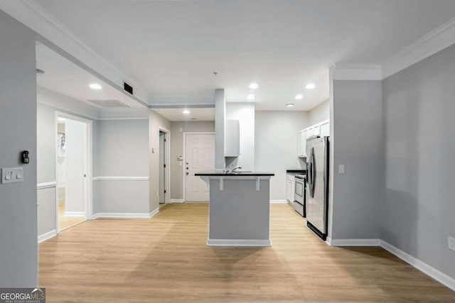 kitchen with light wood-type flooring, white cabinetry, a breakfast bar area, and stainless steel appliances