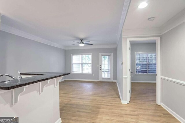 entryway featuring light wood-type flooring, ceiling fan, and ornamental molding