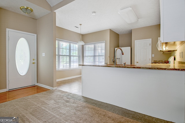 foyer entrance featuring a textured ceiling, light hardwood / wood-style floors, and sink