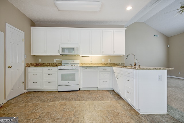 kitchen with sink, lofted ceiling, kitchen peninsula, white cabinetry, and white appliances