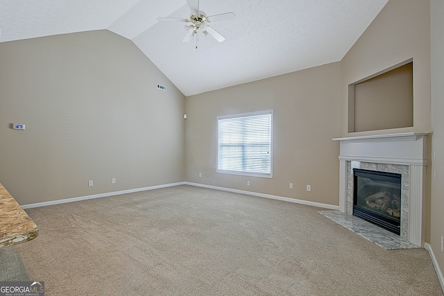 unfurnished living room with a fireplace, vaulted ceiling, ceiling fan, and light colored carpet