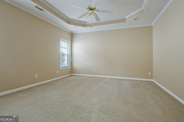 carpeted empty room with ornamental molding, a tray ceiling, ceiling fan, and a textured ceiling