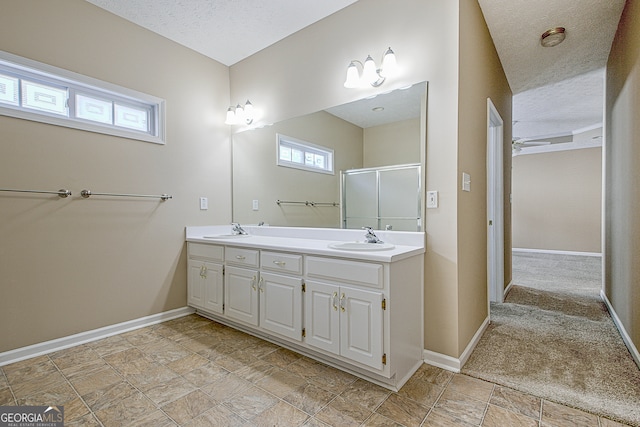 bathroom featuring a textured ceiling, a healthy amount of sunlight, vanity, and an enclosed shower