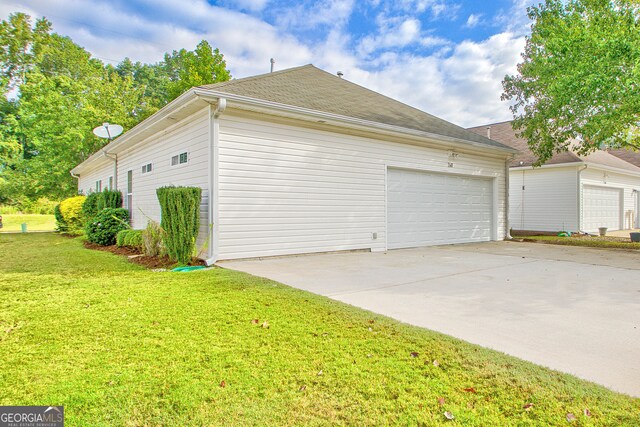 view of property exterior featuring a garage and a lawn