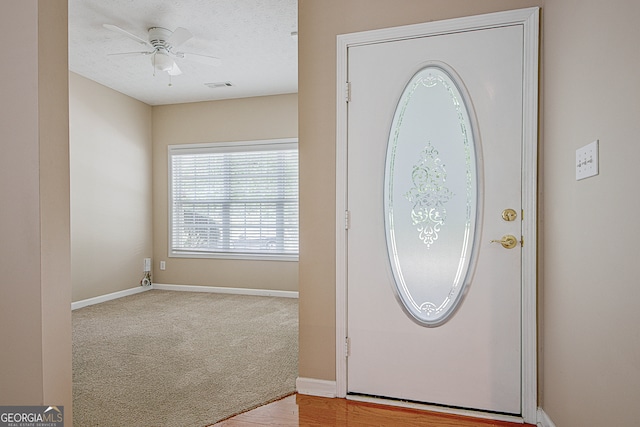 foyer entrance featuring a textured ceiling, ceiling fan, and hardwood / wood-style flooring