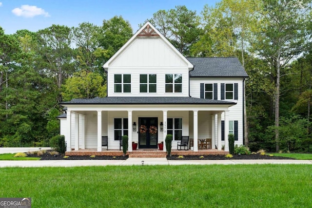 modern farmhouse with a front yard and covered porch