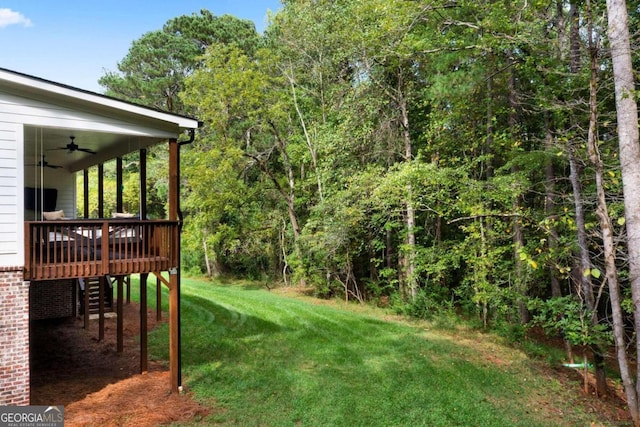 view of yard featuring ceiling fan and a wooden deck