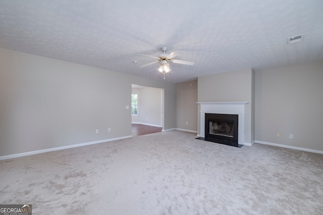 unfurnished living room with carpet, a textured ceiling, and ceiling fan