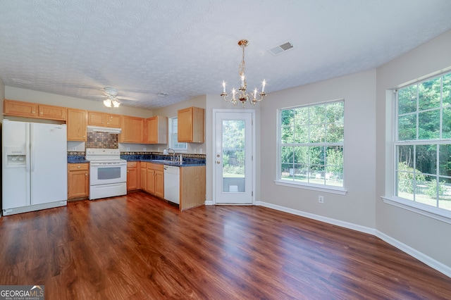 kitchen featuring hanging light fixtures, white appliances, dark hardwood / wood-style floors, and a textured ceiling