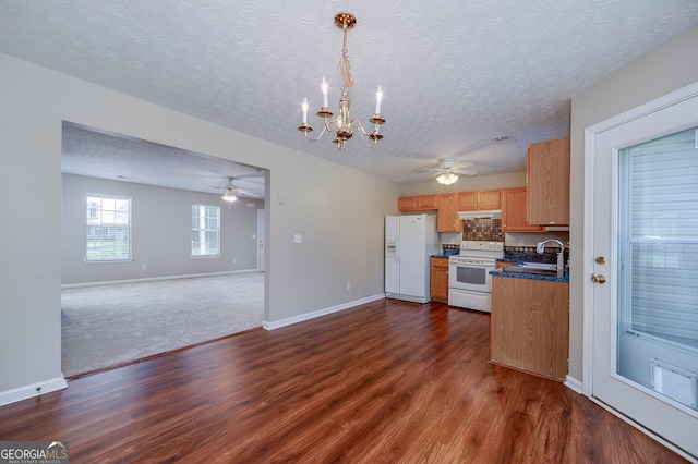 kitchen featuring white appliances, dark hardwood / wood-style floors, a textured ceiling, and sink