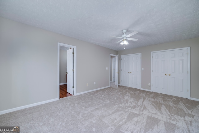 unfurnished bedroom featuring carpet flooring, a textured ceiling, and ceiling fan